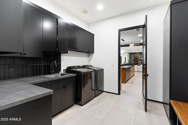 laundry room with visible vents, washer and clothes dryer, light tile patterned floors, cabinet space, and a sink