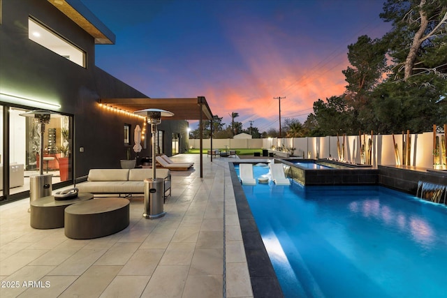 pool at dusk featuring a fenced in pool, an outdoor hangout area, a fenced backyard, a patio area, and an in ground hot tub