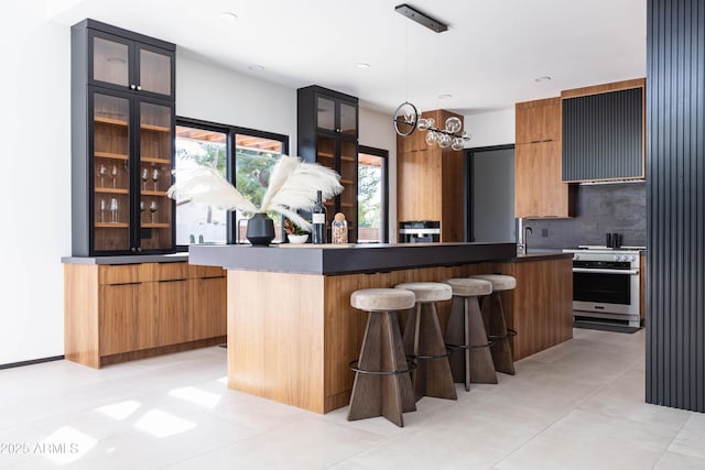 kitchen featuring wall oven, a kitchen breakfast bar, modern cabinets, and glass insert cabinets