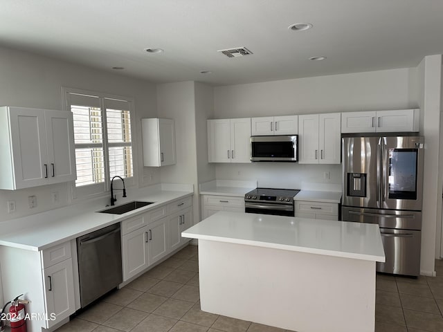 kitchen featuring a center island, stainless steel appliances, white cabinetry, and sink