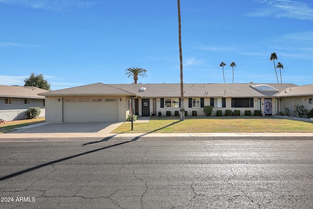 ranch-style home featuring a front lawn and a garage