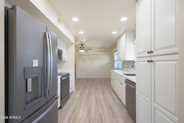 kitchen with decorative backsplash, sink, white cabinetry, and stainless steel appliances