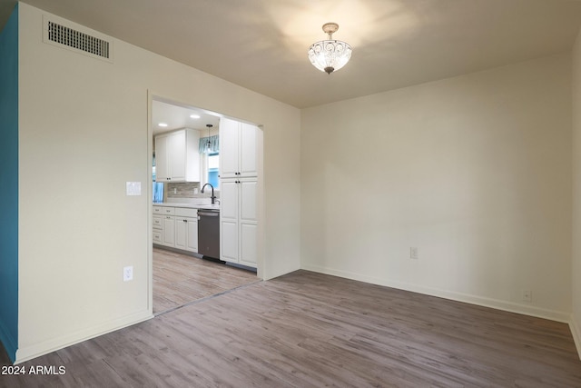 spare room with sink and light wood-type flooring