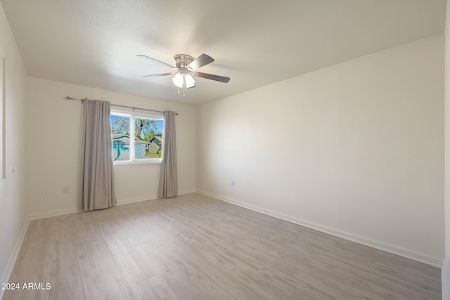 empty room with ceiling fan and light hardwood / wood-style floors