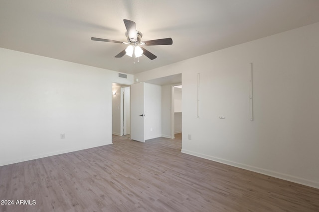 spare room with ceiling fan and light wood-type flooring