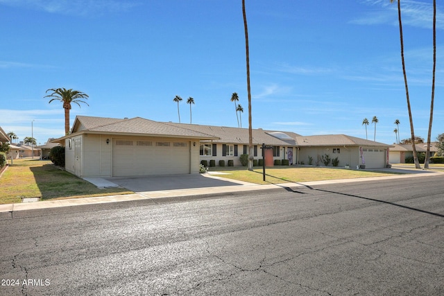 single story home featuring a front yard and a garage