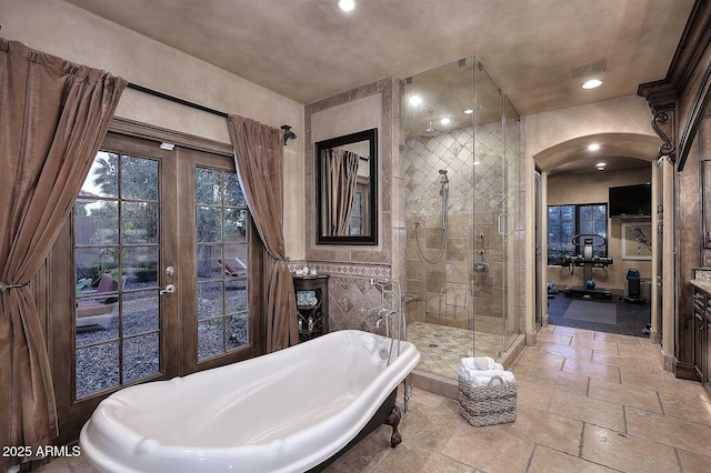 10365 E Paradise Dr, Scottsdale, AZ 85260 - full bathroom featuring visible vents, a soaking tub, recessed lighting, stone tile flooring, and a shower stall