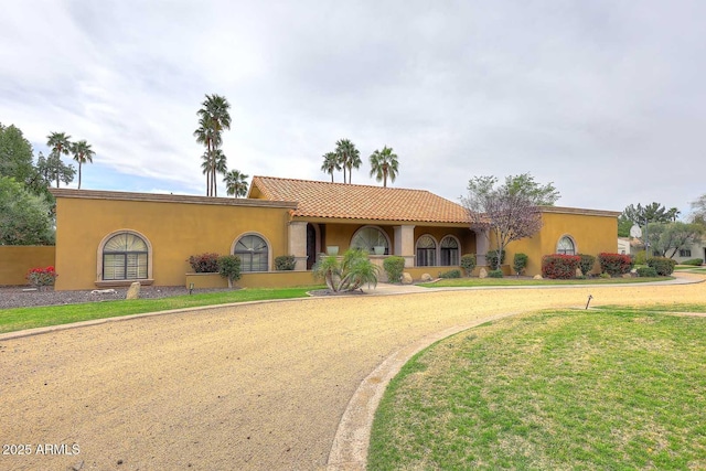 10365 E Paradise Dr, Scottsdale, AZ 85260 - mediterranean / spanish-style house featuring stucco siding, a tile roof, and a front lawn