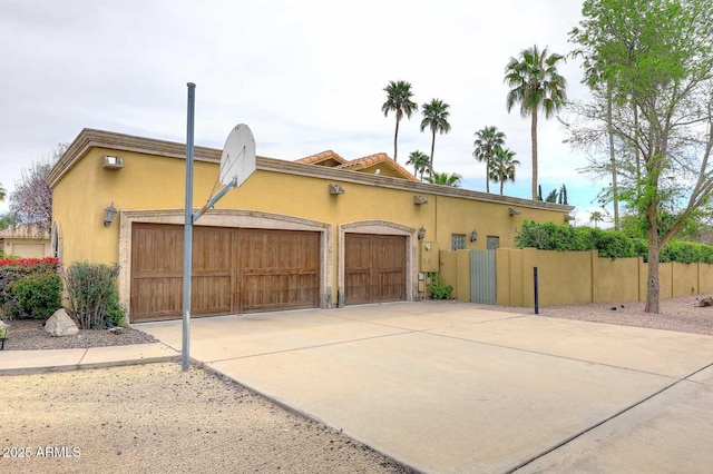 10365 E Paradise Dr, Scottsdale, AZ 85260 - view of front facade featuring an attached garage, fence, driveway, and stucco siding