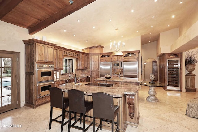 10365 E Paradise Dr, Scottsdale, AZ 85260 - kitchen with a spacious island, decorative backsplash, built in appliances, beamed ceiling, and brown cabinets
