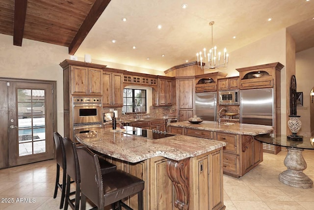 10365 E Paradise Dr, Scottsdale, AZ 85260 - kitchen with lofted ceiling with beams, built in appliances, brown cabinetry, and a large island with sink
