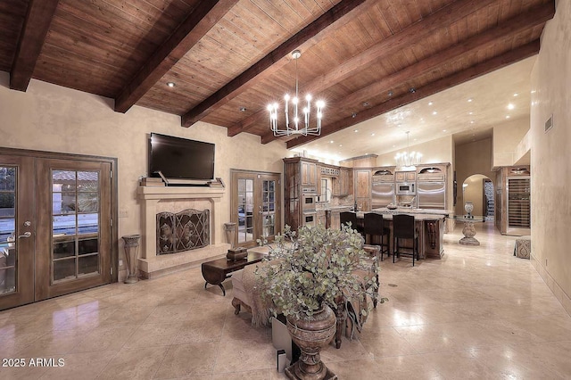 10365 E Paradise Dr, Scottsdale, AZ 85260 - living area featuring beamed ceiling, french doors, arched walkways, an inviting chandelier, and wooden ceiling