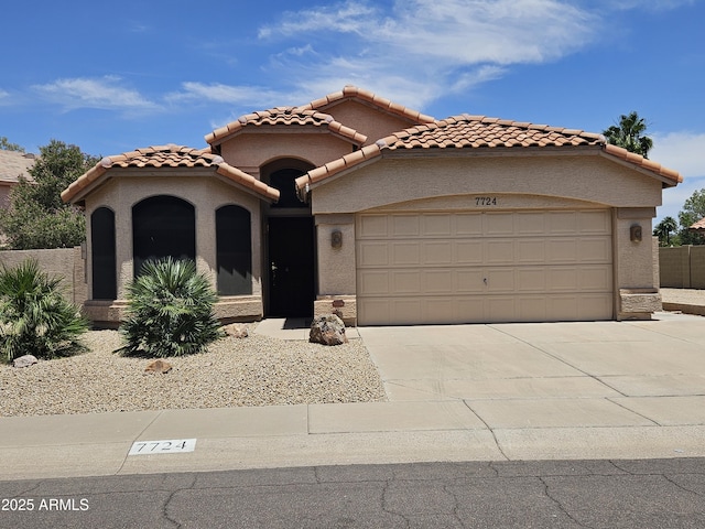 7724 W Topeka Dr W, Glendale, AZ 85308 - mediterranean / spanish house with an attached garage, driveway, stucco siding, and a tiled roof