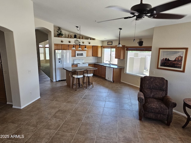 7724 W Topeka Dr W, Glendale, AZ 85308 - kitchen with white appliances, arched walkways, ceiling fan, vaulted ceiling, and a center island