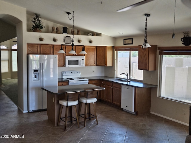 7724 W Topeka Dr W, Glendale, AZ 85308 - kitchen with white appliances, a sink, dark countertops, lofted ceiling, and a kitchen island