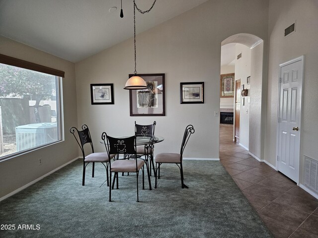 7724 W Topeka Dr W, Glendale, AZ 85308 - dining area featuring arched walkways, baseboards, dark tile patterned floors, dark carpet, and high vaulted ceiling