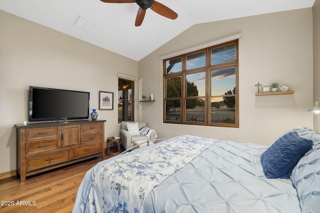 bedroom with hardwood / wood-style flooring, vaulted ceiling, and ceiling fan