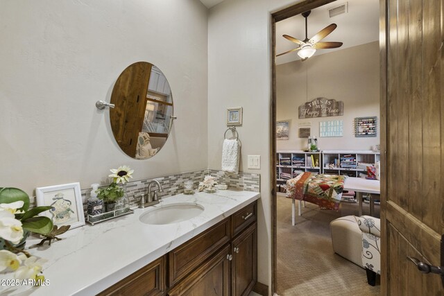 bathroom featuring ceiling fan, vanity, and backsplash