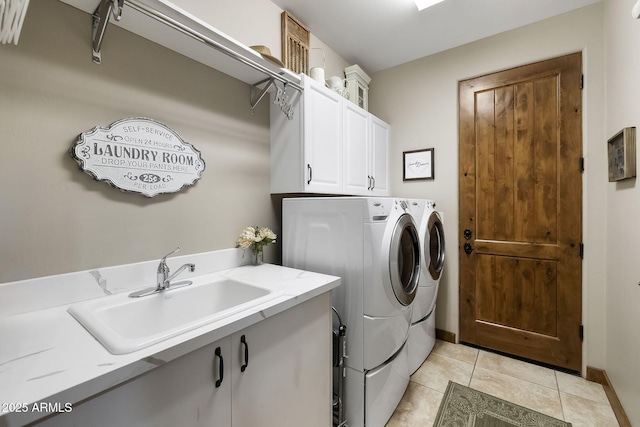 laundry room with cabinets, washing machine and dryer, sink, and light tile patterned flooring