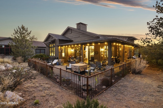 back house at dusk with a patio