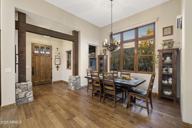 dining area featuring wood-type flooring and a chandelier