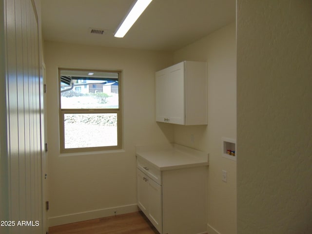 17707 E Jackrabbit Rd, Mayer, AZ 86333 - laundry area featuring hookup for a washing machine, cabinet space, light wood finished floors, and baseboards
