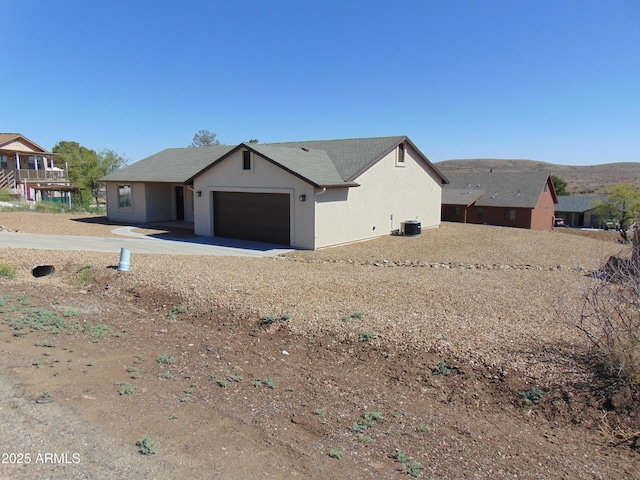 17707 E Jackrabbit Rd, Mayer, AZ 86333 - view of front of home featuring a garage, stucco siding, central AC, and concrete driveway