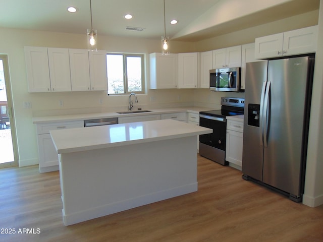 17707 E Jackrabbit Rd, Mayer, AZ 86333 - kitchen with appliances with stainless steel finishes, a sink, a kitchen island, white cabinets, and light countertops