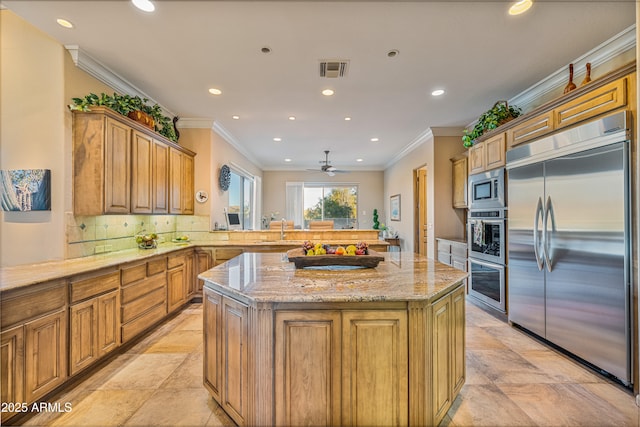 kitchen with kitchen peninsula, built in appliances, a center island, and light stone counters