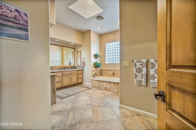 bathroom featuring vanity and tiled tub