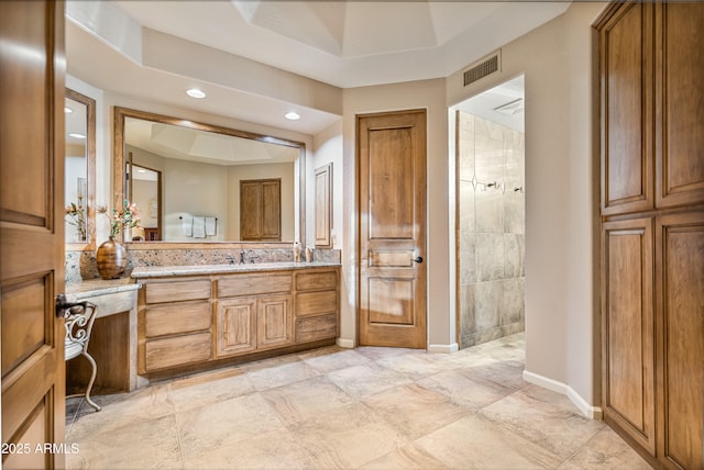 bathroom featuring vanity, a raised ceiling, and walk in shower