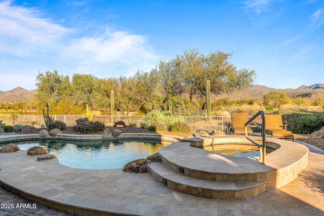 view of swimming pool featuring a mountain view, a patio area, and an in ground hot tub