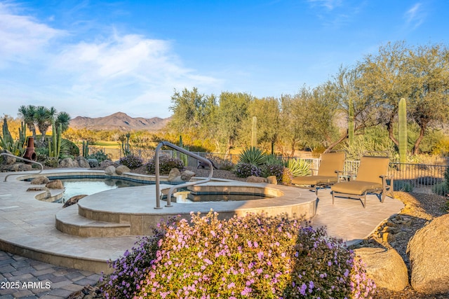 exterior space with a mountain view, an in ground hot tub, and a patio area