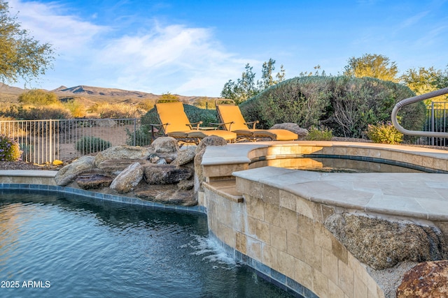 view of pool featuring a jacuzzi, a mountain view, and pool water feature