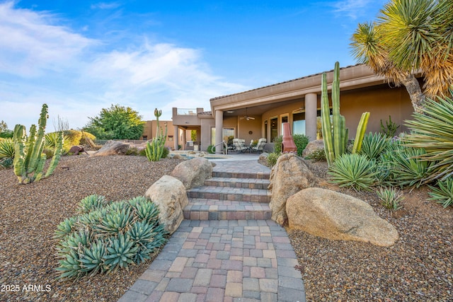 pueblo-style house with ceiling fan and a patio area