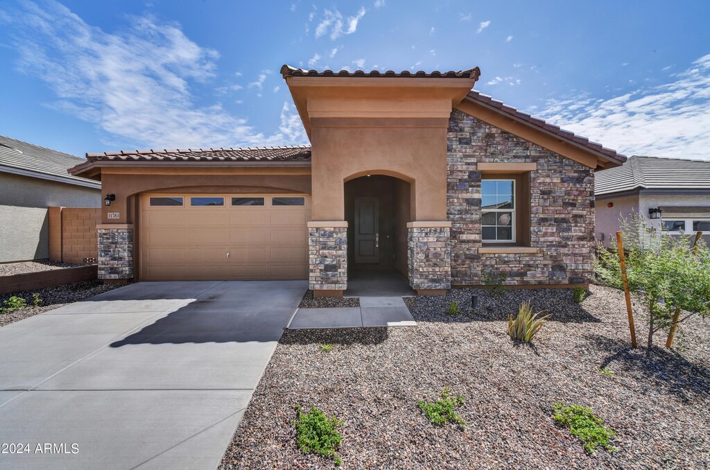 31783 N 130th Ave, Peoria, AZ 85383 - mediterranean / spanish home with stone siding, driveway, an attached garage, and stucco siding
