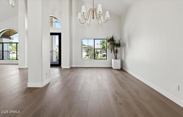 10755 E Cholla Ln, Scottsdale, AZ 85259 - unfurnished dining area with high vaulted ceiling, a chandelier, dark wood-style flooring, and baseboards