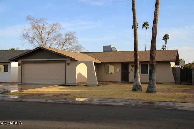 ranch-style house with central air condition unit, a garage, a shingled roof, concrete driveway, and stucco siding