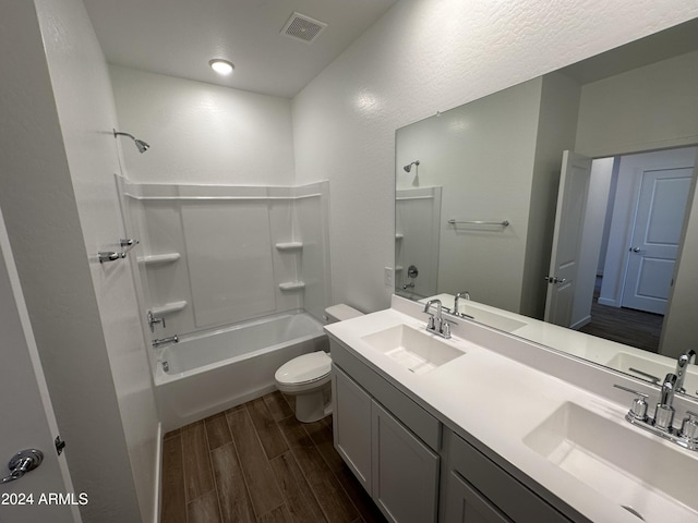 full bathroom with washtub / shower combination, vanity, hardwood / wood-style flooring, and toilet