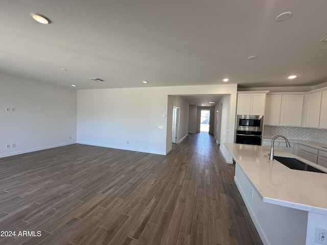 kitchen featuring light stone countertops, white cabinetry, sink, stainless steel appliances, and dark hardwood / wood-style flooring