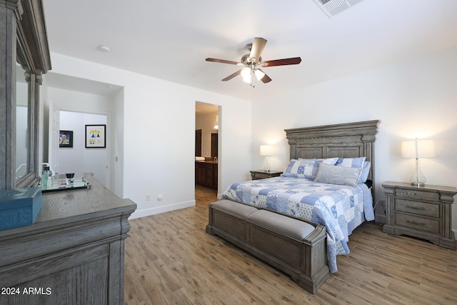 bedroom with light wood-type flooring, ensuite bathroom, and ceiling fan