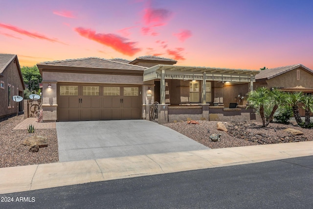 prairie-style home featuring a garage and a pergola