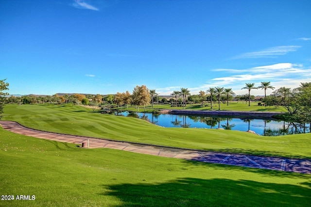 view of property's community with a water view and a lawn