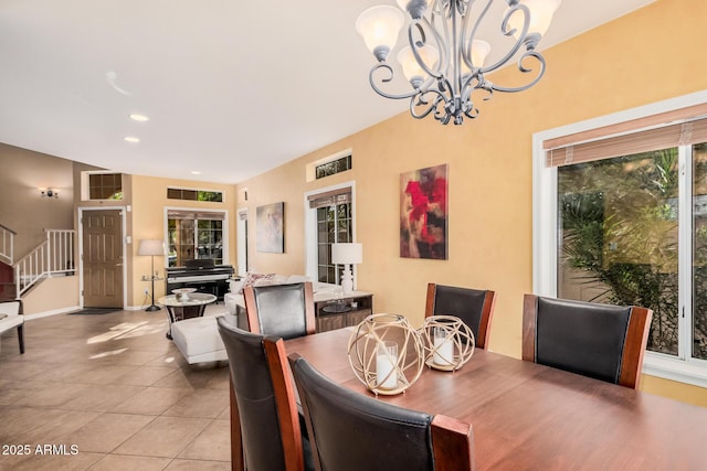 dining room with light tile patterned floors, a notable chandelier, a healthy amount of sunlight, and stairs