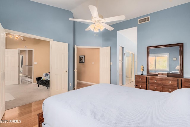 bedroom featuring visible vents, high vaulted ceiling, a ceiling fan, a closet, and light wood-style floors