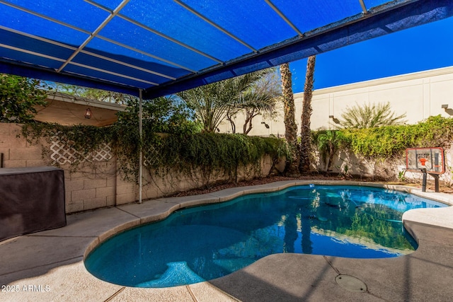 view of swimming pool featuring a fenced in pool, glass enclosure, and a fenced backyard