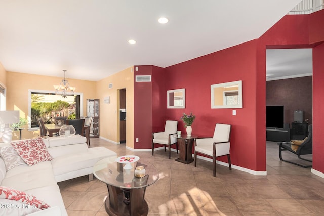 living room with an accent wall, an inviting chandelier, baseboards, and visible vents