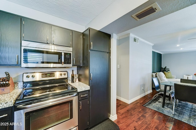 5122 E Shea Blvd Unit 1020, Scottsdale, AZ 85254 - kitchen featuring dark wood-style flooring, baseboards, visible vents, and appliances with stainless steel finishes