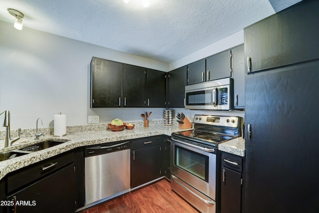 5122 E Shea Blvd Unit 1020, Scottsdale, AZ 85254 - kitchen featuring a sink, a textured ceiling, dark wood-style flooring, and stainless steel appliances