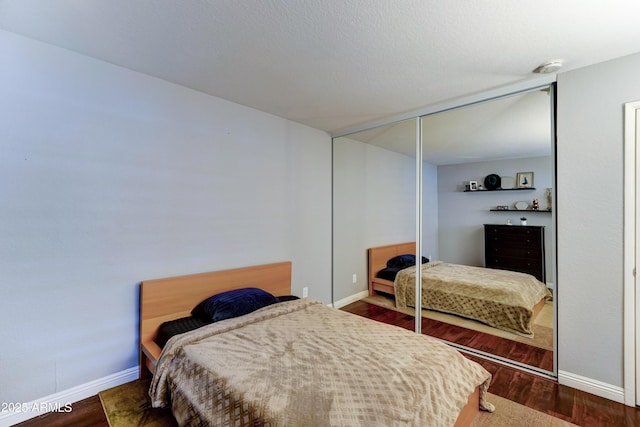 5122 E Shea Blvd Unit 1020, Scottsdale, AZ 85254 - bedroom with a closet, baseboards, and wood finished floors